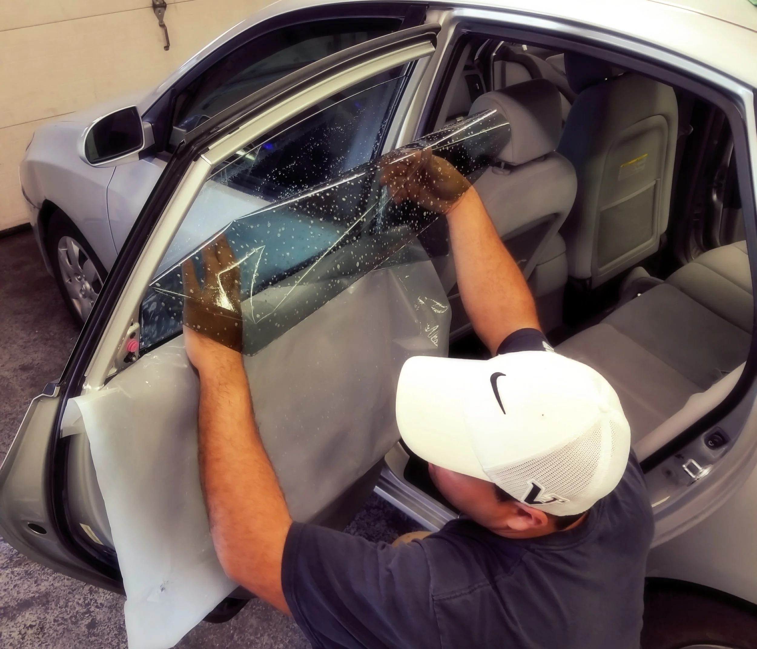 Professional window tint being installed on a vehicle